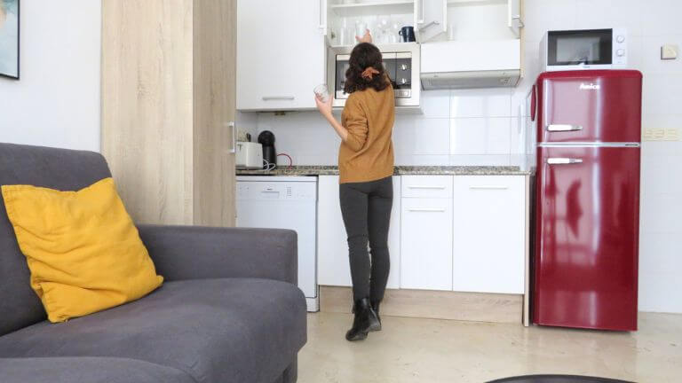 mujer en la cocina de un apartamento para alquilar por meses en Valencia